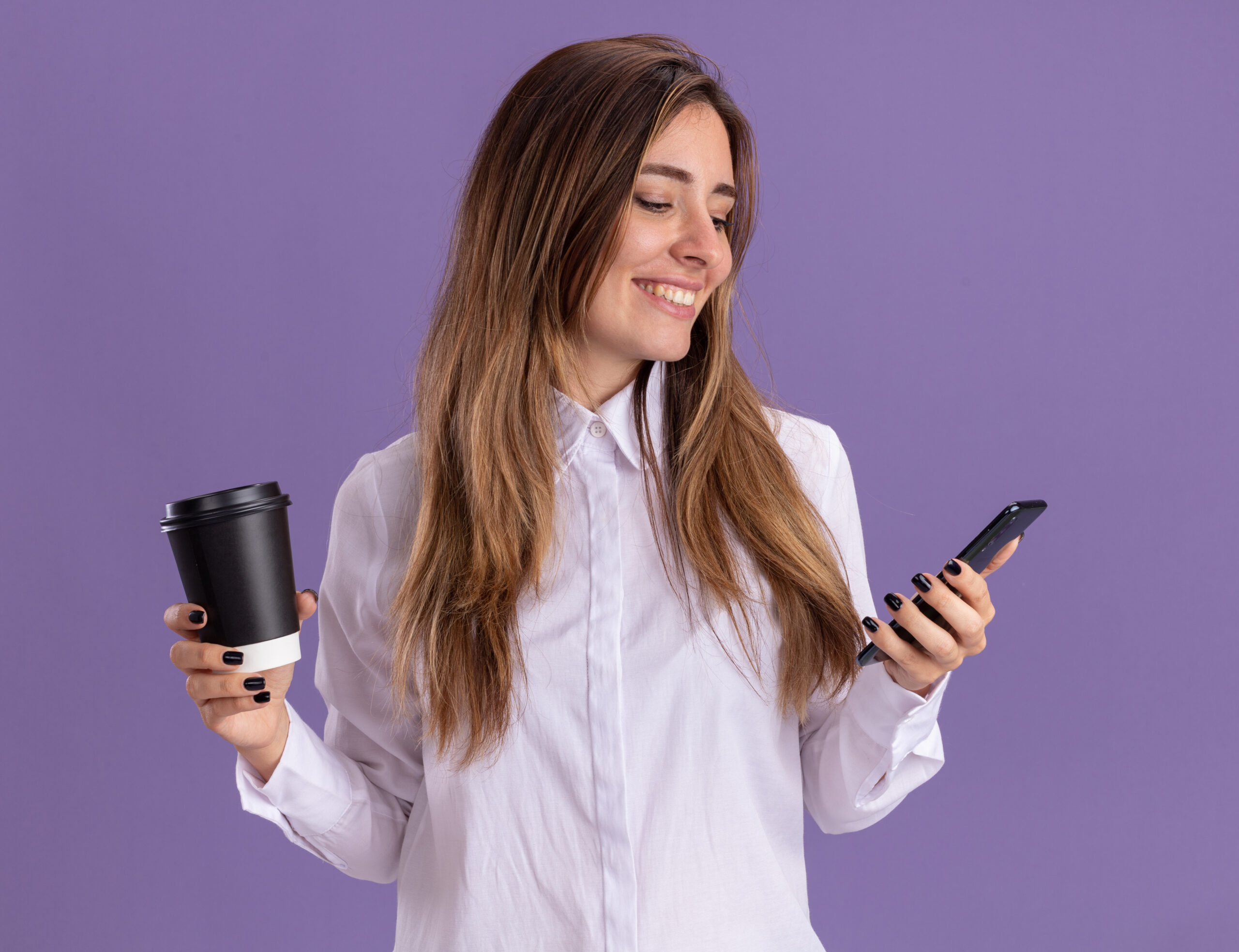 Femme professionnelle heureuse et souriante qui tient son téléphone cellulaire, café à l'autre main et qui consulte C.A.I.L., ton coach AI en vente.